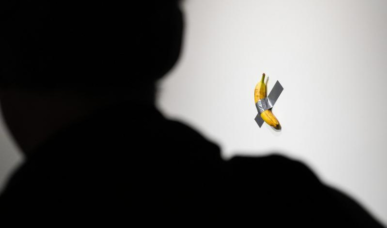 Siapa yang Menghasilkan $1 Juta dari Perdagangan Meme Coin yang Terinspirasi oleh Pisang Tempelan Duct-Tape Cattelan? Twitter Menunjuk pada Pegawai Sotheby's.